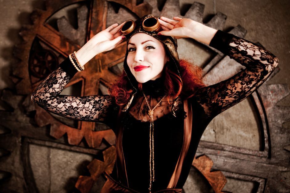 Woman in lace and leather steampunk outfit adjusting her goggles