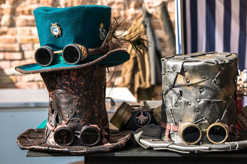 Two steampunk top hats decorated with goggles and metallic elements