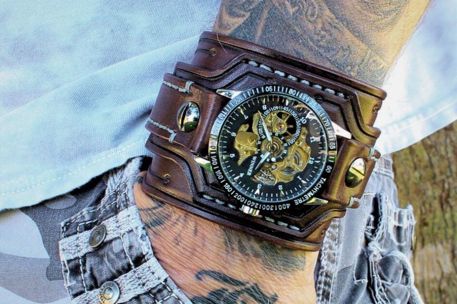 Close-up of a man wearing a steampunk-style leather cuff watch with exposed gears and brown leather band