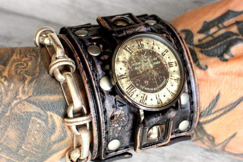 Close-up of men’s watches with leather bands featuring a wide cuff design and vintage dial in distressed black leather.
